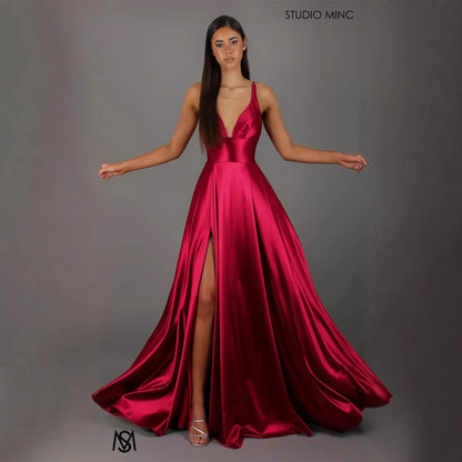 Red satin evening gown with deep V-neck, high slit, and flowing A-line skirt for formal events