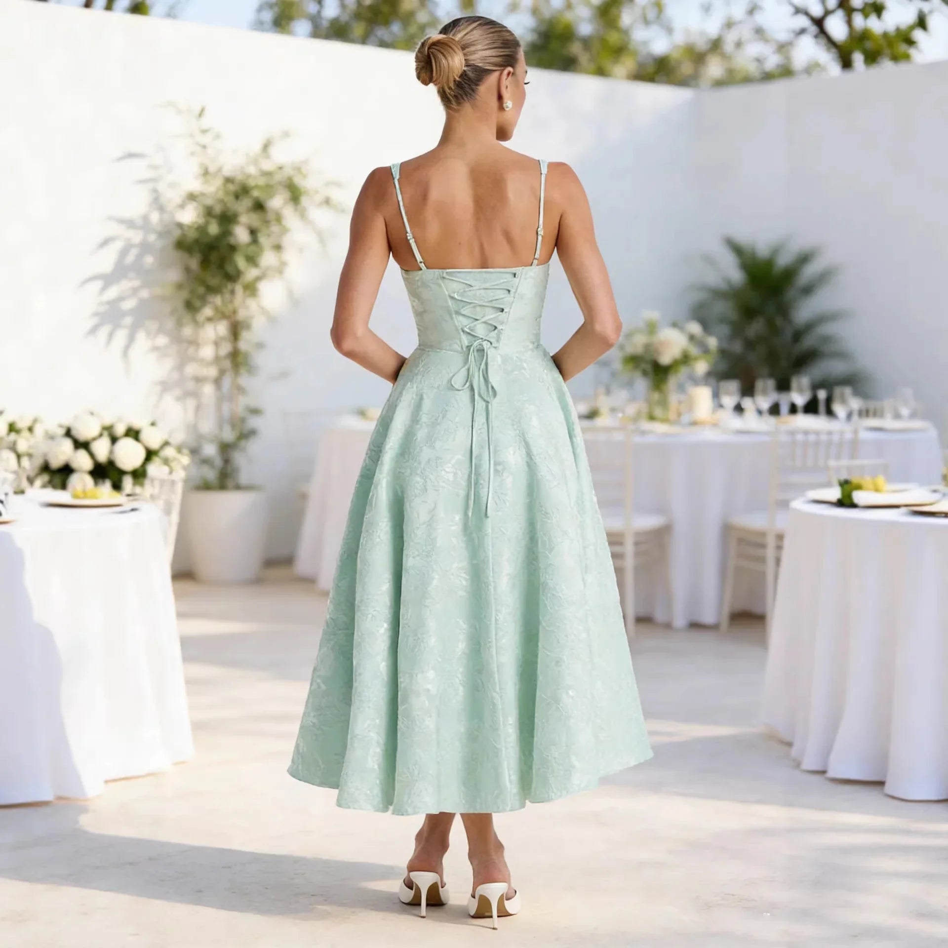 Mint green lace midi dress with back lace-up detail, thin straps, and flared skirt for wedding guest or formal events