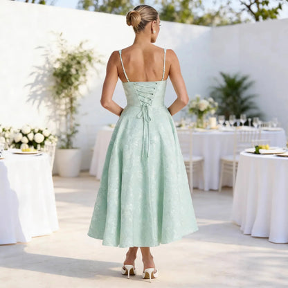 Mint green lace midi dress with back lace-up detail, thin straps, and flared skirt for wedding guest or formal events