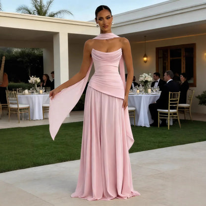 Elegant blush pink evening gown with draped neckline and flowing cape, perfect for formal events and weddings