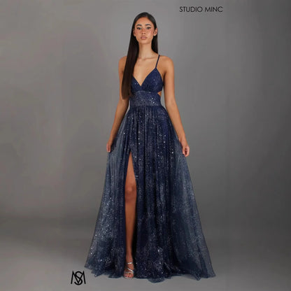 Navy blue sequin evening gown with V-neck, spaghetti straps, side slit, and flowing tulle skirt for formal events