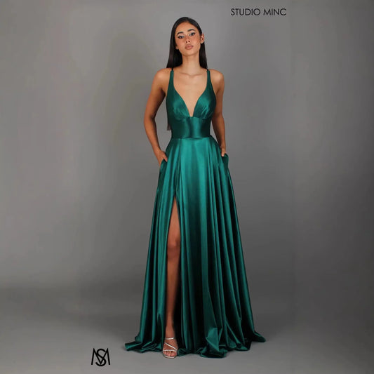 Emerald green satin evening gown with deep V-neck, high slit, and pockets, ideal for formal events and prom