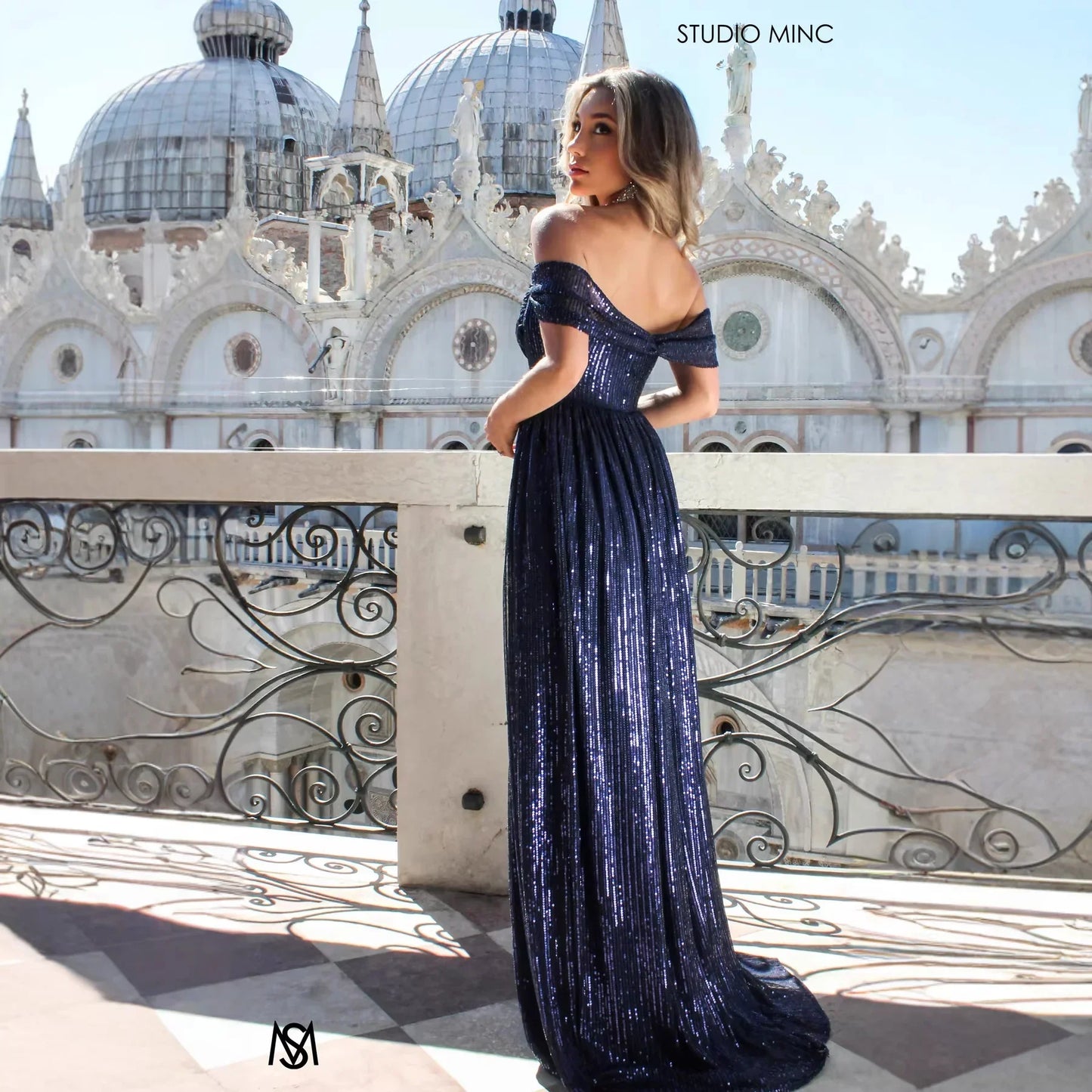 Navy blue sequin off-shoulder maxi dress with flowing skirt, perfect for evening events and formal occasions.