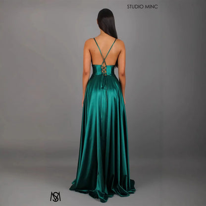 Emerald green satin evening gown with crisscross back straps and lace-up detail, floor-length formal dress